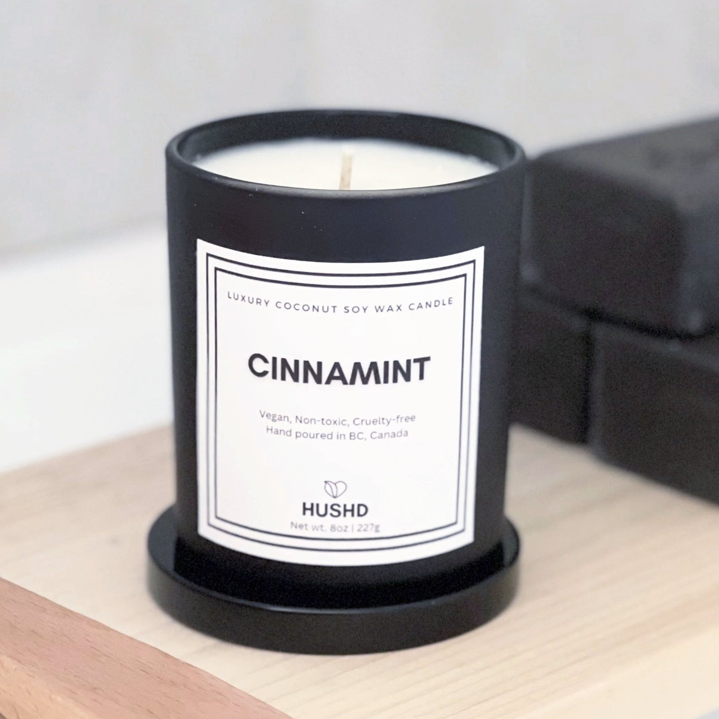 Hand poured Cinnamint natural candle in reusable matte black glass jar with spicy mint aroma. Eco-friendly, vegan and available online.