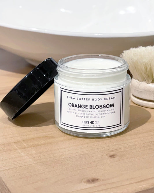 Orange Blossom Shea Butter Body Cream in clear glass jar with black lid