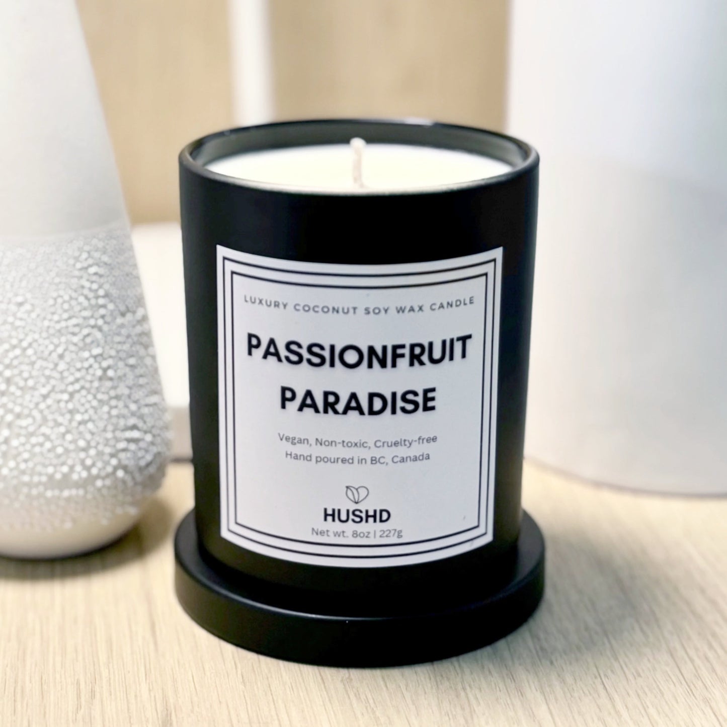 Hand poured Passionfruit Paradise candle in reusable matte black glass jar with fruity and floral aroma, eco friendly, buy online.