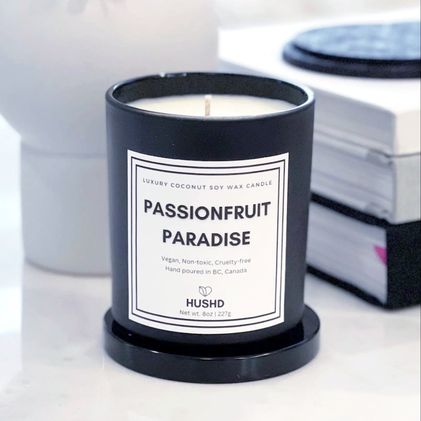 Passionfruit Paradise coconut soy candle in matte black jar with orange, pineapple and jasmine scent, hand poured in Canada, shop now.