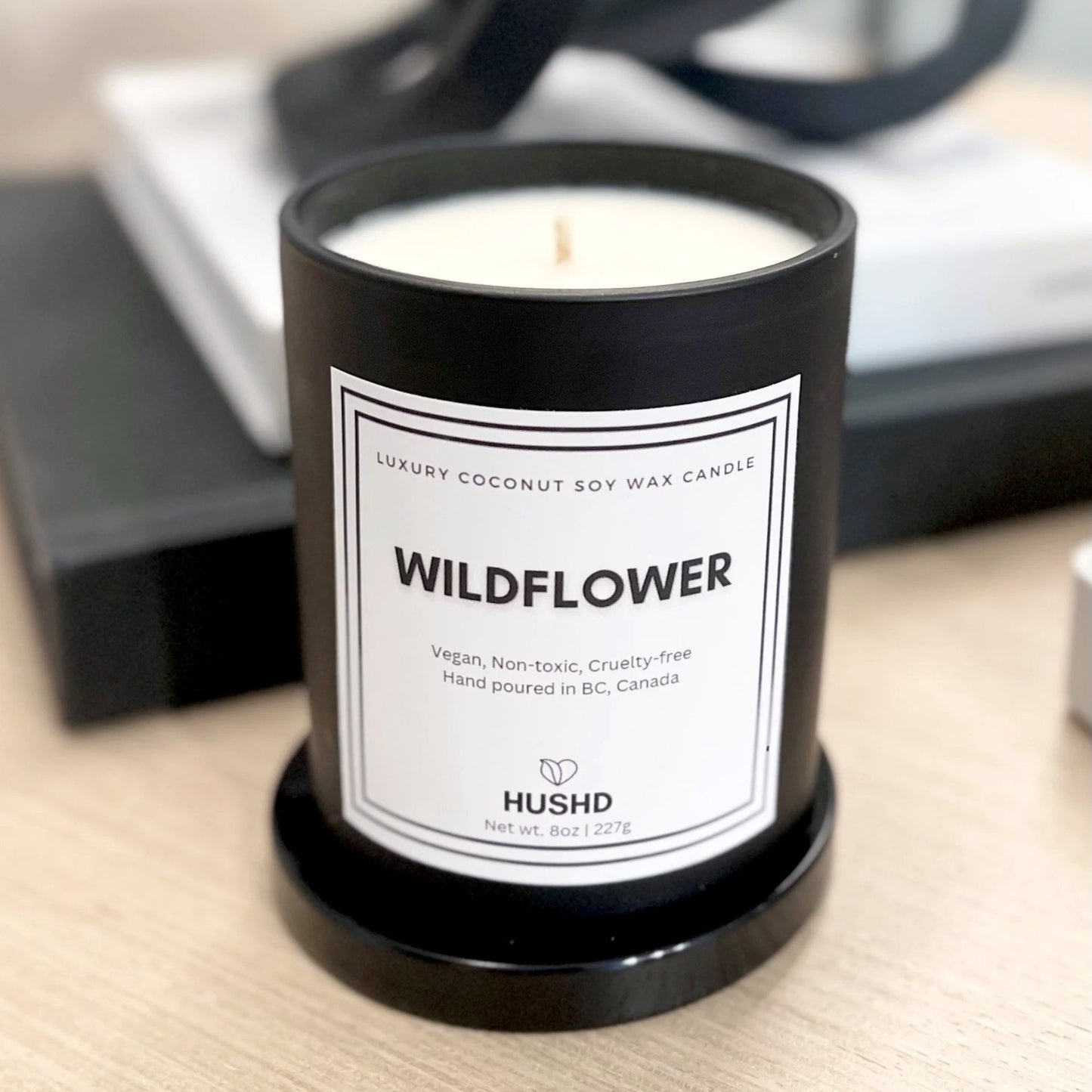Wildflower coconut soy candle with peony, tuberose and amber notes in matte black jar, handmade in Canada.