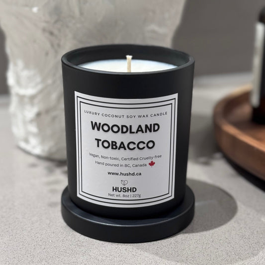 Woodland Tobacco coconut soy candle in matte black jar with orange, vanilla and amber notes - hand-poured in Canada, shop now.